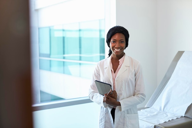 Portrait de femme médecin avec tablette numérique en salle d'examen