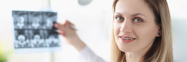 Portrait de femme médecin tenant une photo radiographique