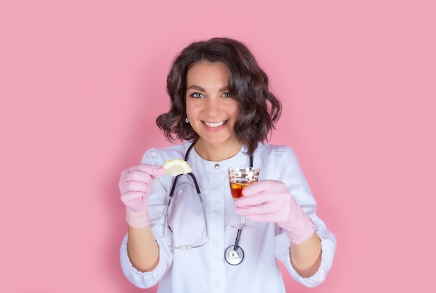 Portrait d'une femme médecin vêtue d'un uniforme médical avec un verre de boisson alcoolisée forte