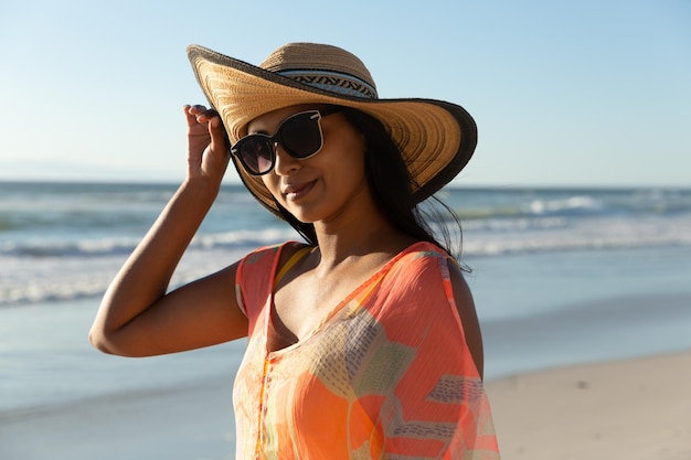 Portrait d'une femme métisse souriante en vacances à la plage. loisirs en plein air sains au bord de la mer.