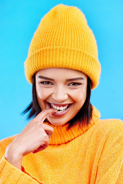 Portrait de femme à la mode d'hiver avec bonnet de visage heureux et sourire isolé sur fond bleu Style bonheur et fille gen z en maquette de fond de studio et flirter des vêtements chauds pour le temps froid