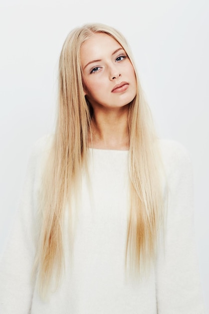 Portrait de femme et mode pour le style de beauté naturelle ou le soin des cheveux sur un fond de studio blanc Visage de jeune femme blonde ou modèle attrayant en vêtements décontractés avec maquillage et cosmétiques