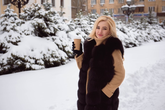 Portrait de femme à la mode de style européen, boire du café à winter park.