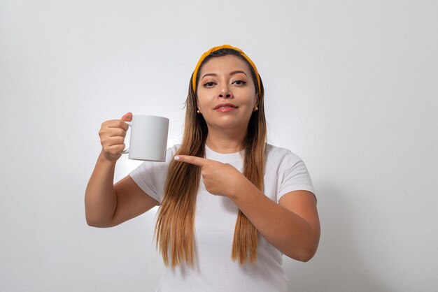 Portrait de femme montrant une tasse blanche Personne tenant une tasse de café fond blanc