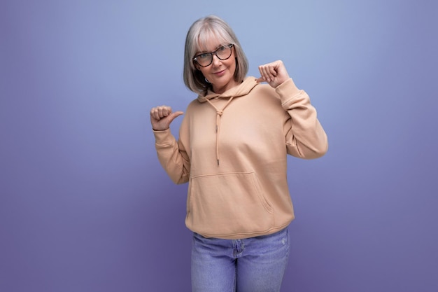 Portrait de femme mûre moderne en sweat-shirt sur fond de studio avec espace de copie