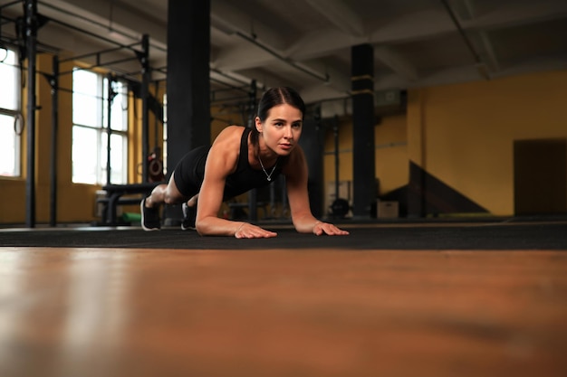 Portrait d'une femme musclée sur une position de planche.