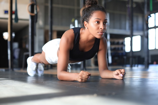 Portrait d'une femme musclée sur une position de planche.