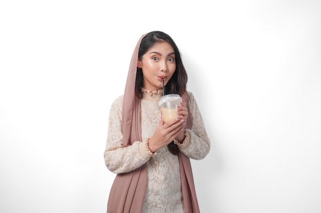 Portrait d'une femme musulmane asiatique en foulard, voile, hijab, soif après le jeûne et buvant du café dans une tasse en plastique, concept du Ramadan