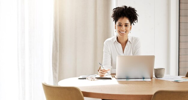 Portrait d'une femme noire et d'un bureau pour un ordinateur portable d'entreprise et une start-up qui planifient des recherches sur Internet Femme entrepreneur Afro-américaine en ligne pour la stratégie marketing et sourire avec maquette