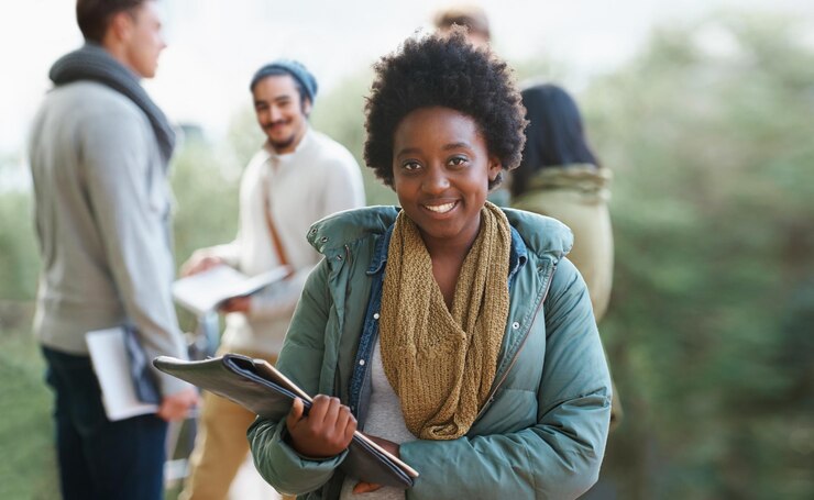 Photo portrait de femme noire et étudiante en plein air avec des livres pour étudier l'apprentissage et l'éducation pour la croissance académique bourse de connaissances et diplôme avec un sourire sur le campus collège avec un manuel ou un dossier