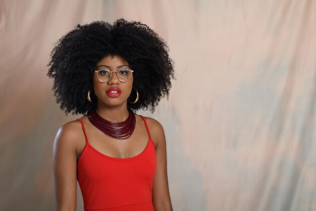 Portrait d'une femme noire portant des lunettes transparentes et des vêtements rouges