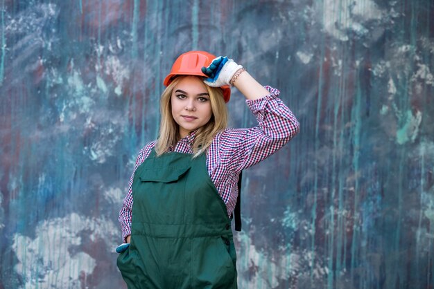 Portrait de femme ouvrier builder debout porter l'uniforme et la barre. Rénovation de la maison.