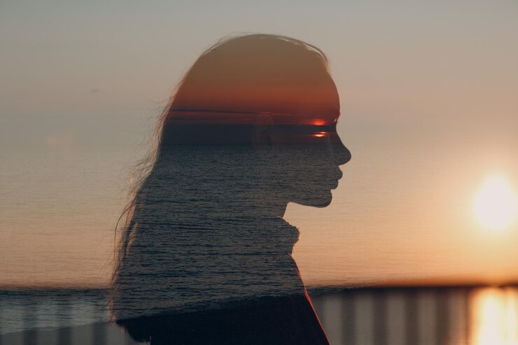 Photo portrait d'une femme par la mer contre le ciel au coucher du soleil