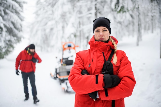 Portrait de femme paramédic du service de secours en montagne à l'extérieur en hiver en forêt