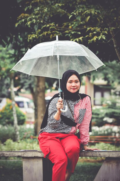 Photo portrait d'une femme avec un parapluie debout sous la pluie pendant la saison des pluies