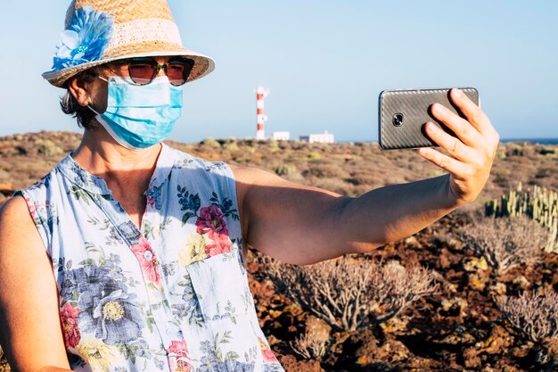 Portrait d'une femme photographiant avec un téléphone portable