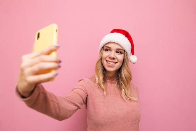 portrait femme portant bonnet de noel avec téléphone