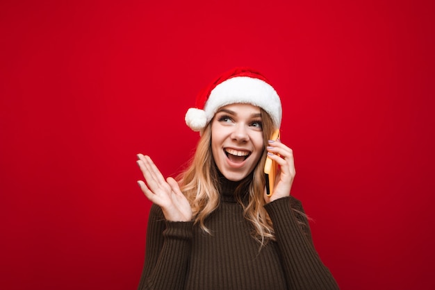 portrait femme portant bonnet de noel avec téléphone