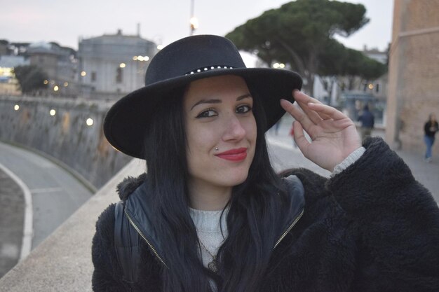 Photo portrait d'une femme portant un chapeau souriant au pont