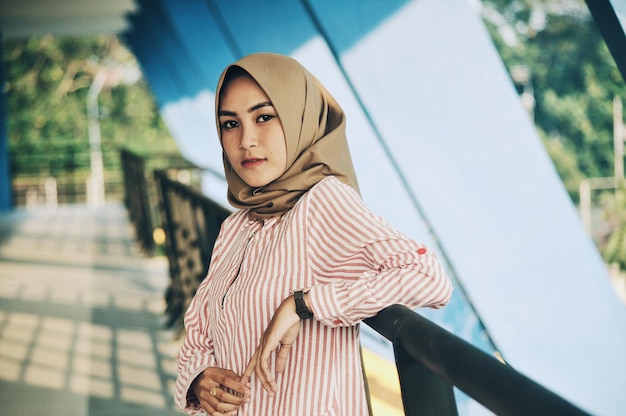 Portrait d'une femme portant un hijab alors qu'elle se tient près d'une balustrade