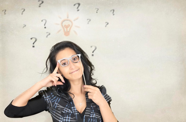 Photo portrait d'une femme portant des lunettes de nouveauté avec des points d'interrogation en fond