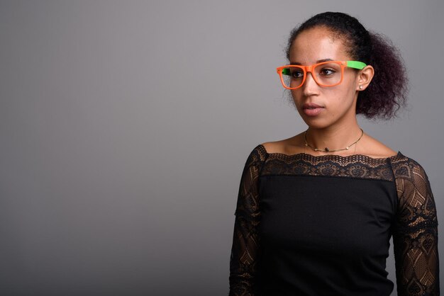 Portrait d'une femme portant des lunettes de soleil sur un fond gris