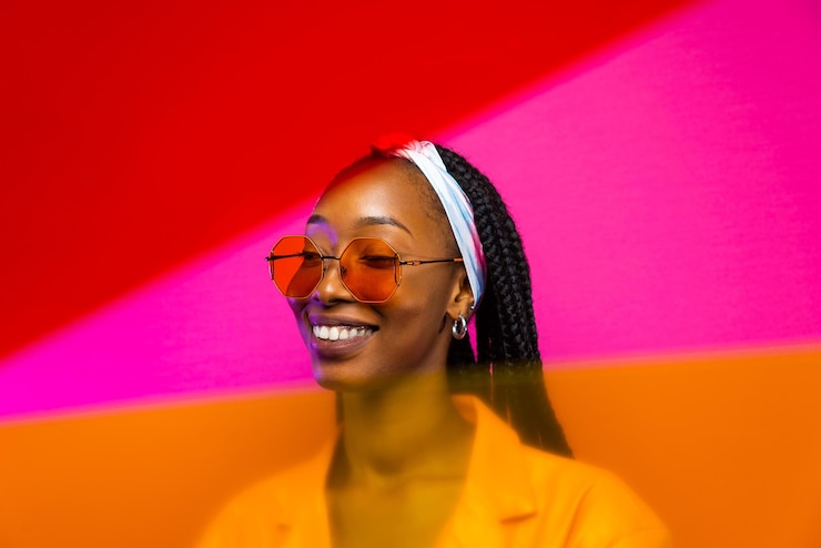 Photo portrait d'une femme portant des lunettes de soleil sur un fond rose