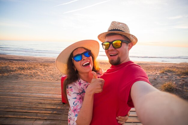 Portrait d'une femme portant des lunettes de soleil sur la plage contre le ciel