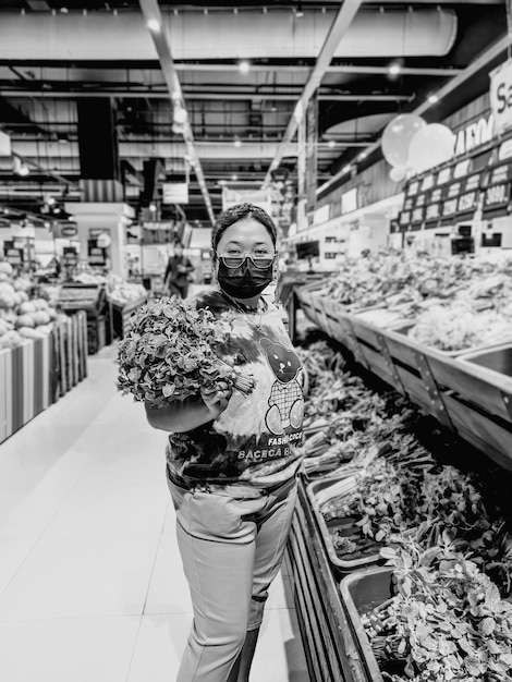 Photo portrait d'une femme portant un masque debout sur le marché