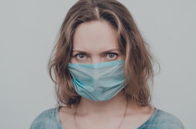 Portrait d'une femme portant un masque médical regardant la caméra isolée allergie à la poussière épidémique de grippe