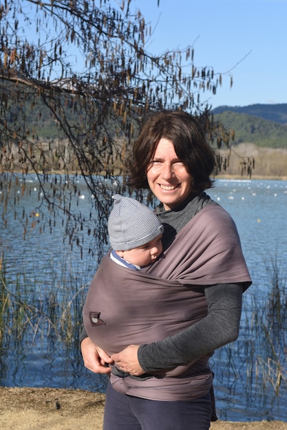 Portrait d'une femme portant son enfant environnement naturel