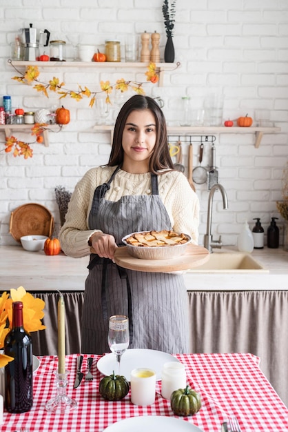 Portrait d'une femme préparant une tarte à la citrouille pour le dîner de Thanksgiving à la cuisine à domicile