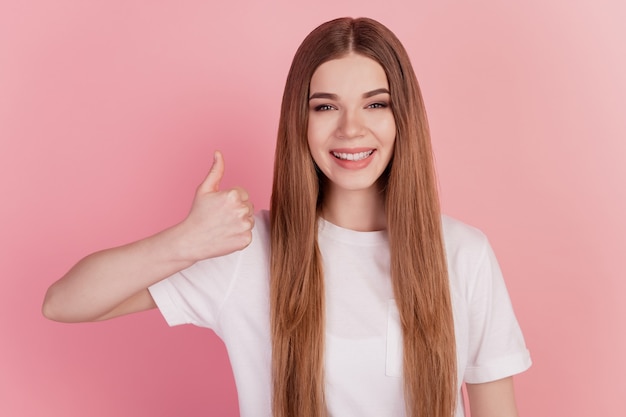 Portrait de femme promoteur lever le pouce vers le haut sourire rayonnant sur fond rose