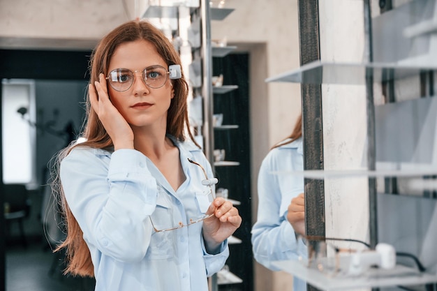 Photo portrait de femme qui porte des lunettes dans le magasin choisir les bonnes lunettes pour corriger la vision