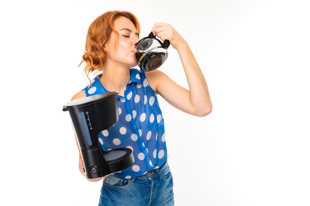 Portrait de femme de race blanche aux cheveux roux, joli visage en t-shirt bleu et short avec aspirateur