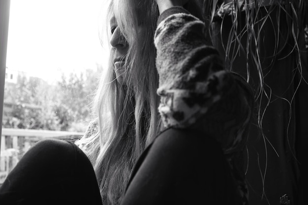 Photo portrait d'une femme regardant par la fenêtre