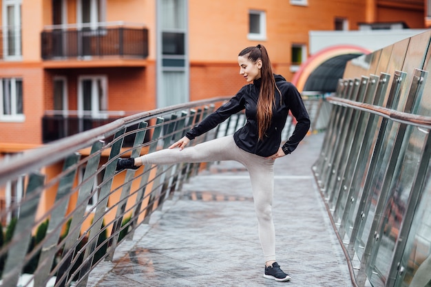 Portrait d'une femme de remise en forme faisant des exercices d'étirement dans les escaliers.