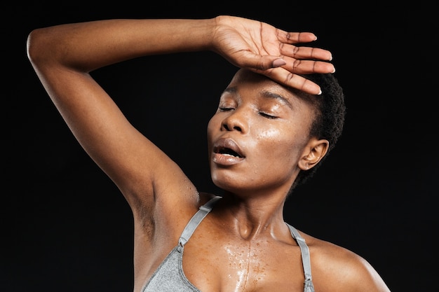 Portrait d'une femme de remise en forme posant isolé sur un mur noir