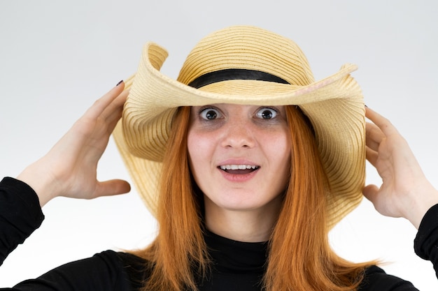 Portrait de femme rousse drôle en chapeau de paille jaune sac.