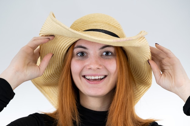 Portrait de femme rousse drôle en chapeau de paille jaune sac.