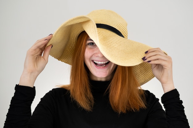 Portrait de femme rousse drôle en chapeau de paille jaune sac.