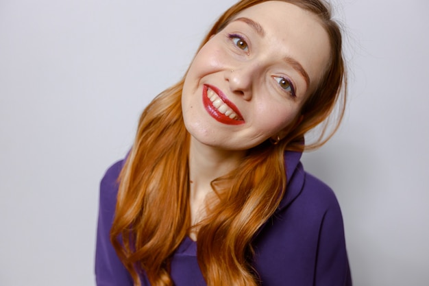 Portrait d'une femme rousse souriante dans une capuche violette