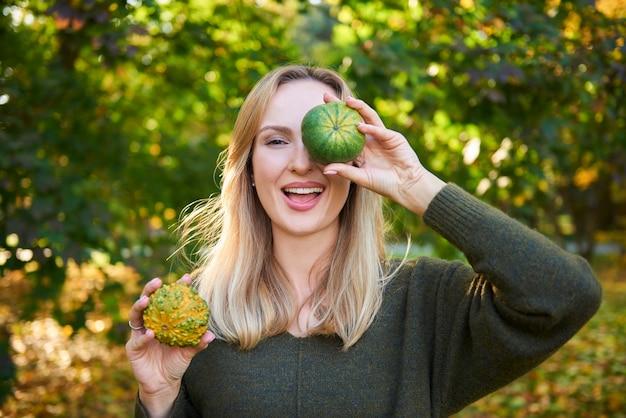 Portrait de femme s'amusant avec citrouille