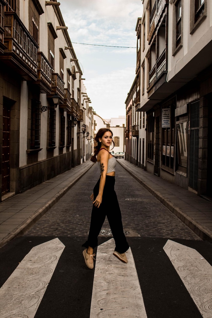 Photo portrait d'une femme sautant sur la route en ville