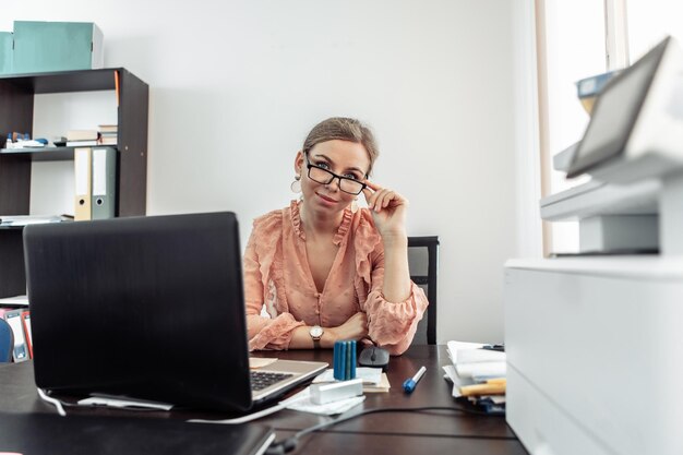 Portrait de femme secrétaire avec des lunettes à l'espace de travail