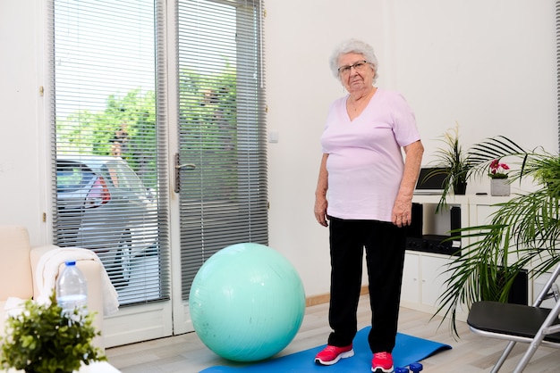 Portrait d'une femme senior active et dynamique faisant du sport à la maison