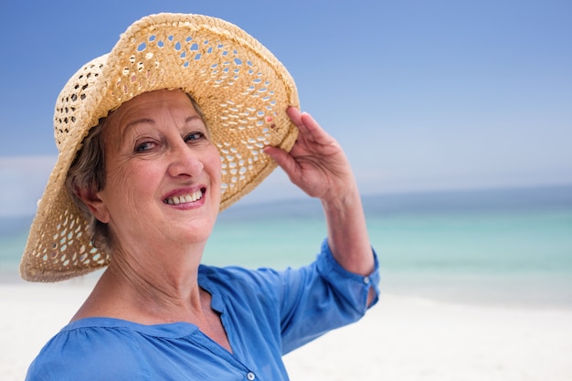 Portrait de femme senior heureuse en chapeau de plage