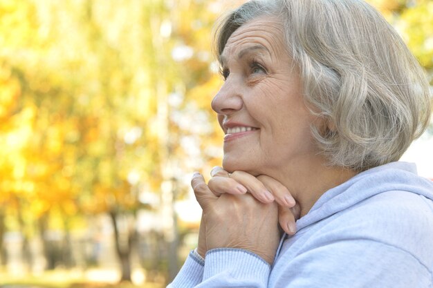 Portrait d'une femme senior heureuse dans le parc d'automne