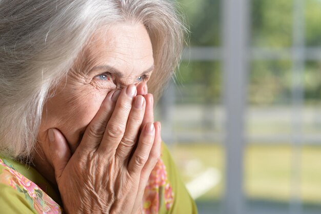 Portrait d'une femme senior heureuse posant à la maison