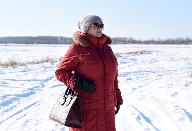 Portrait de femme senior russe à l'écart contre champ neigeux